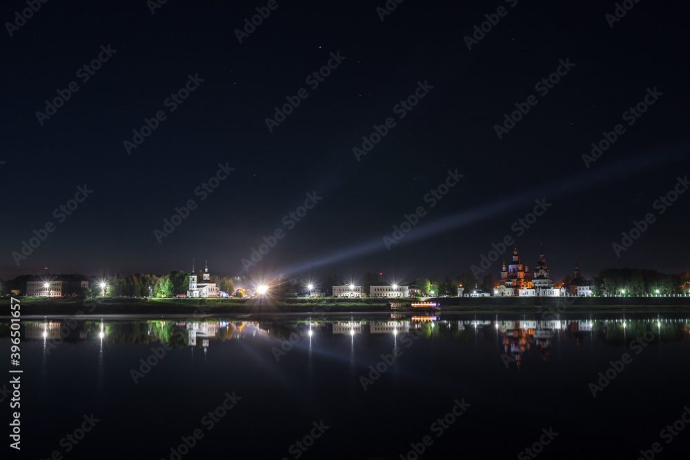 embankment of an ancient city reflected in the river at night