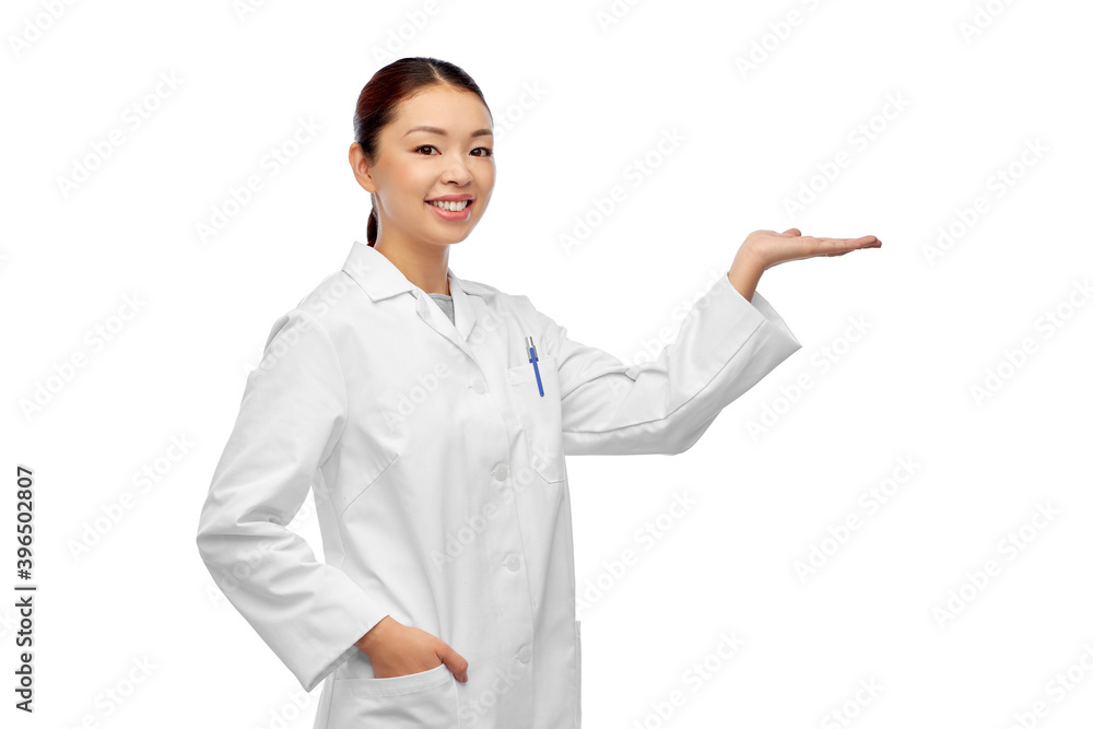 medicine, profession and healthcare concept - happy smiling asian female doctor or scientist in white coat holding something imaginary on her hand medicine, profession and healthcare concept - happy smiling asian female doctor or scientist in white coat holding something imaginary on her hand