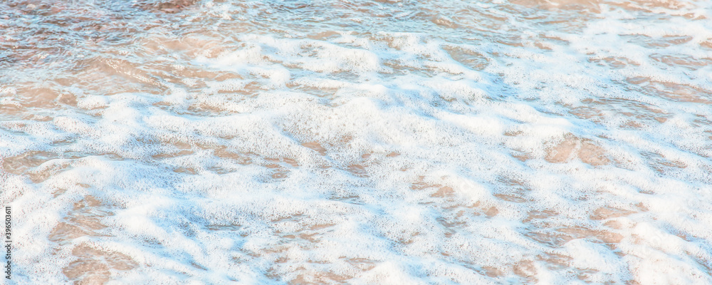the waves of the sea on the sandy beach on a sunny day