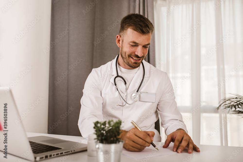 Portrait of a handsome young doctor sitting in his office. Portrait of a handsome young doctor sitting in his office.