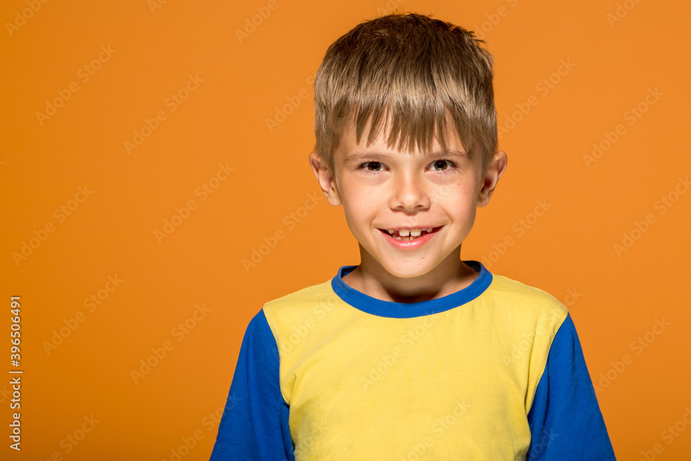 Close-up portrait of smiling boy standing against bright wall at home Close-up portrait of smiling boy standing against bright wall at home