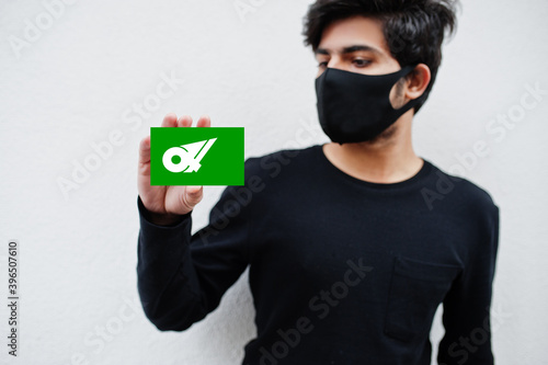 Japanese man wear all black with face mask hold Mie flag in hand isolated on white background. Prefectures of Japan сoronavirus concept. photo