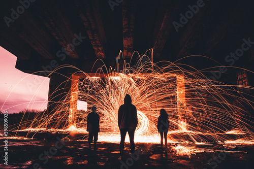 Siluetas de personas a contraluz delante de chispas y fuego dentro de un túnel