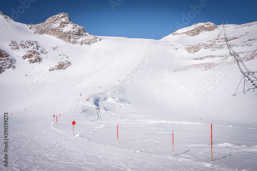Winter landscape in the Alps. Mayrhofen sports region in the Zillertal. Ski slopes in the background of mountains. Skiers descend a difficult black slope © Alexey Oblov