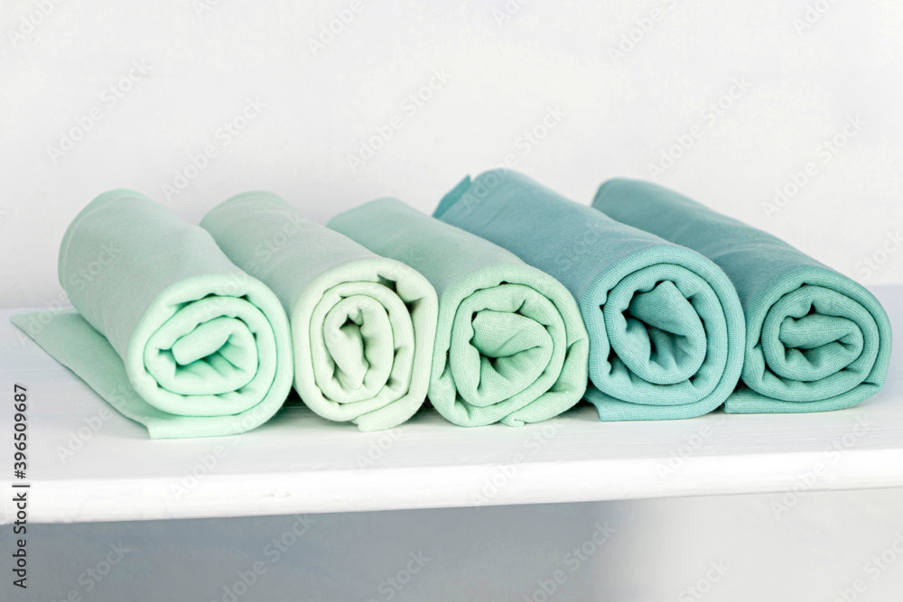 Ταπετσαρία Rolls of knitted fabric of different shades, blue, burgundy on a white backgroun