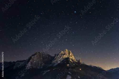 Dolomites by nightSky with stars on a winter night in val di fassa. Dolomites, forest and night lights of Pozza di Fassa photo