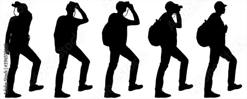 Tourist in a baseball cap with binoculars in hands. Boy examines everything from the sides through binoculars and stands with leg raised. Man with a backpack on his back. Ornithologist. Black shadows.