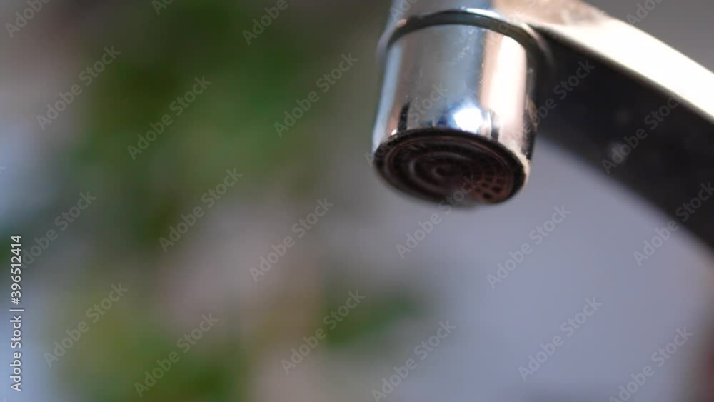 Water dripping from the faucet of a sink. Water dripping from the faucet of a sink.