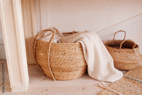 wicker basket made of recycled materials with beige towel inside. smart storage. reasonable consumption of materials, monochrome beige, selective focus