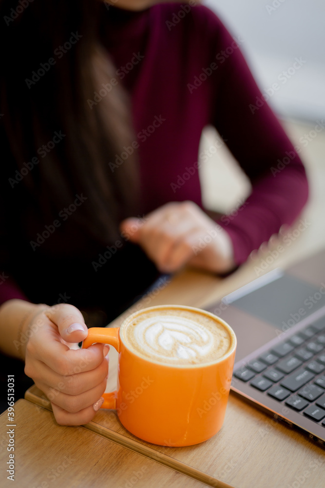 A girl has a croissant for Breakfast in a cafe