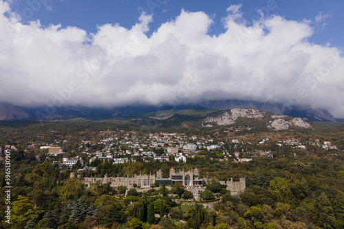 Aerial drone photo of Vorontsov palace, huge green famous garden against the mountains hidden in fog in sunny day, sightseeing in the Crimea © Elena