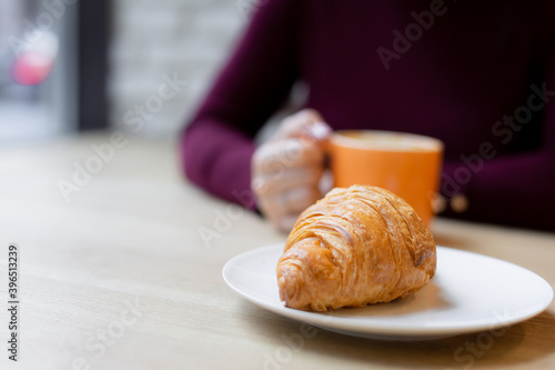 Wallpaper Mural A girl has a croissant for Breakfast in a cafe Torontodigital.ca