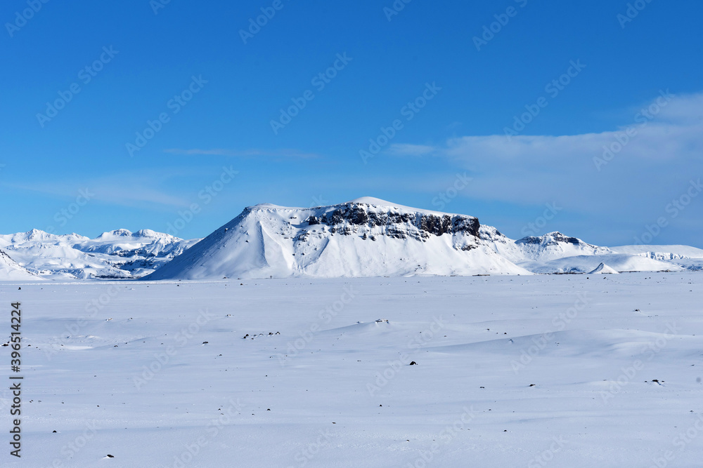 Typical Icelandic winter landscape with mountains under the snow and blue sky. Beautiful winter landscape with mountains covered snow, cold frosty weather and white field in Iceland. Typical Icelandic winter landscape with mountains under the snow and blue sky. Beautiful winter landscape with mountains covered snow, cold frosty weather and white field in Iceland.