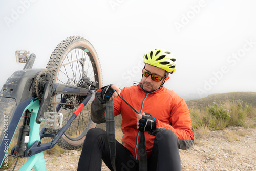 Φωτογραφία Cyclist repairs a puncture in the wheel of his bicycle