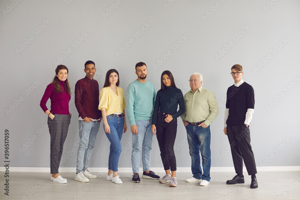 Obraz premium Group of diverse people in casual clothes standing together and looking at camera