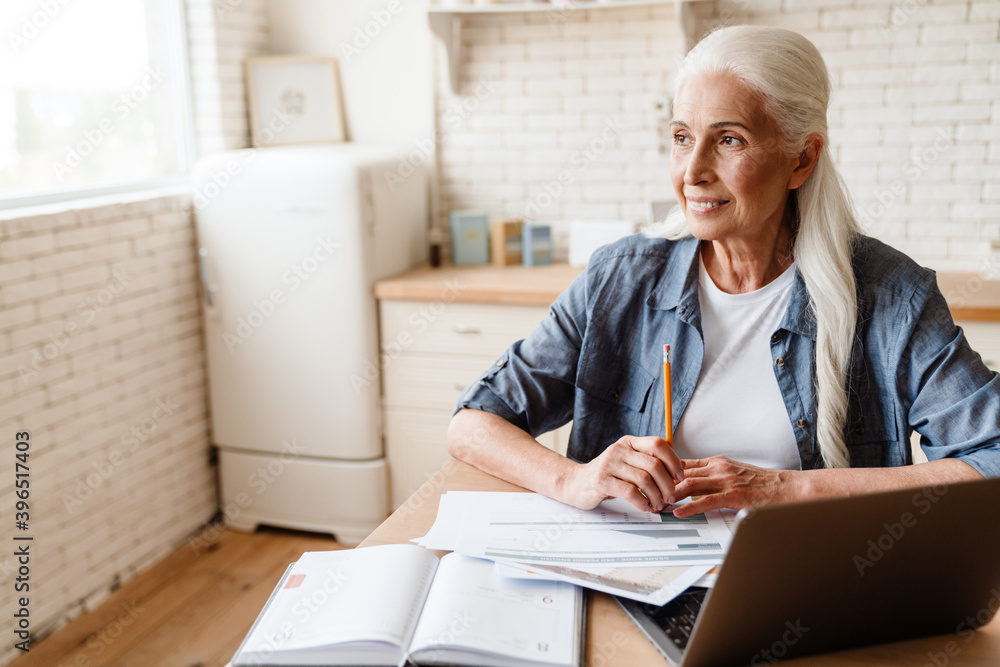 Pensive mature middle aged woman using laptop Pensive mature middle aged woman using laptop