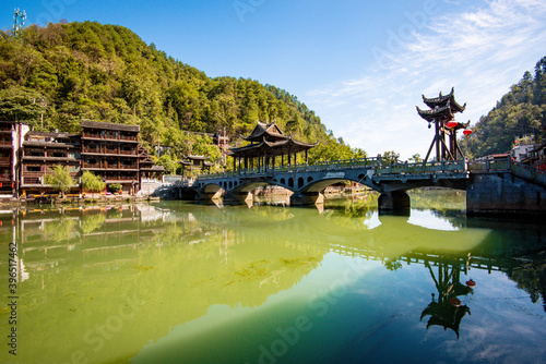 the river, the boat, stone bridge and the old houses at ancient phoenix town in the morning at Hunan, China.