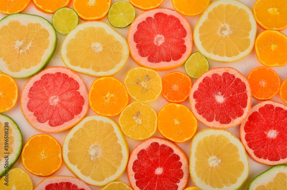 Sliced citrus fruits background. Red grapefruit, oranges, lemons, lime, mandarins Sliced citrus fruits background. Red grapefruit, oranges, lemons, lime, mandarins