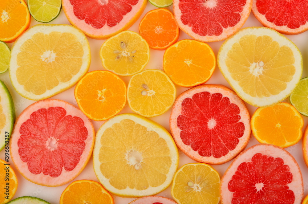 Sliced citrus fruits background. Red grapefruit, oranges, lemons, lime, mandarins Sliced citrus fruits background. Red grapefruit, oranges, lemons, lime, mandarins