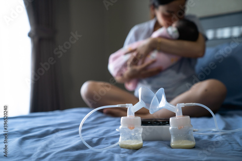 Mom use electric breast pump feeding for her baby.