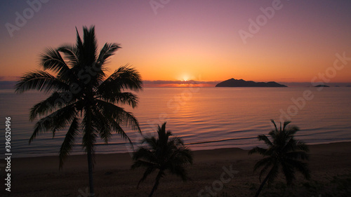Fototapeta Naklejka Na Ścianę i Meble -  Beautiful Sunset in Australia Palm foreground dunk island in background on mission beach