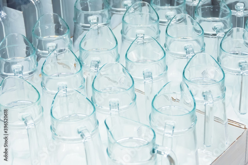 Many new glass jugs on a shelf in a store, home utensils for sale. © aapsky