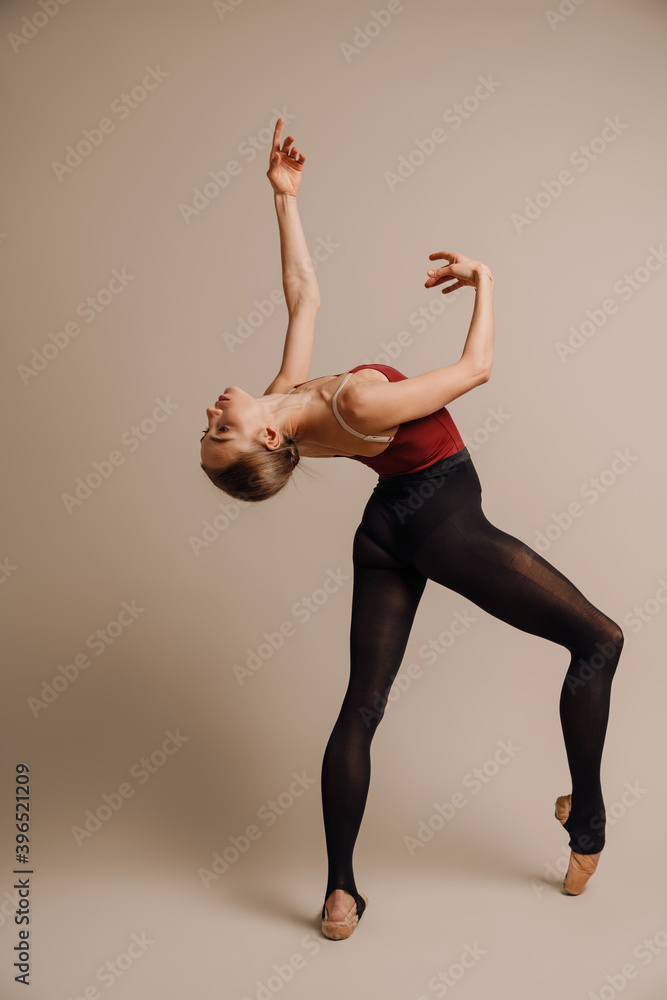 Beautiful young focused ballerina dancing gracefully on camera