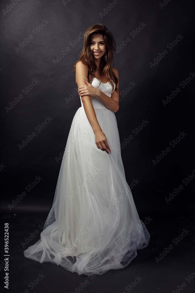 Full length body size photo of woman in white wedding dress smiling happy isolated on dark color studio background