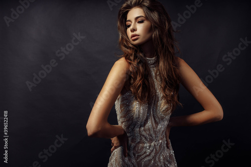 Photo portrait of pretty woman in fancy dress wavy hairstyle posing looking empty space isolated dark color studio background