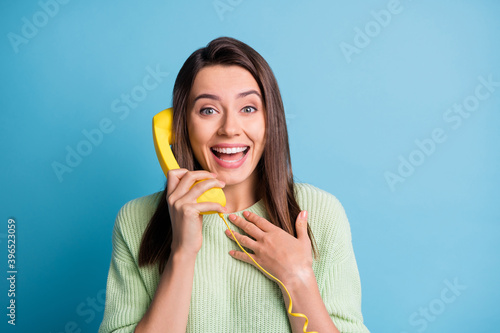 Photo of positive cheerful girl call telephone her friend laugh touch hand chest wear pullover isolated on blue color background