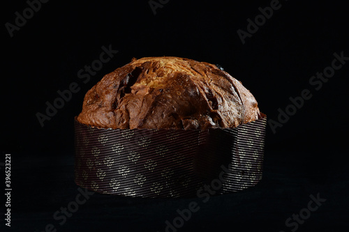 artisanal panettone typical from Milano area on black background whit cutting light
