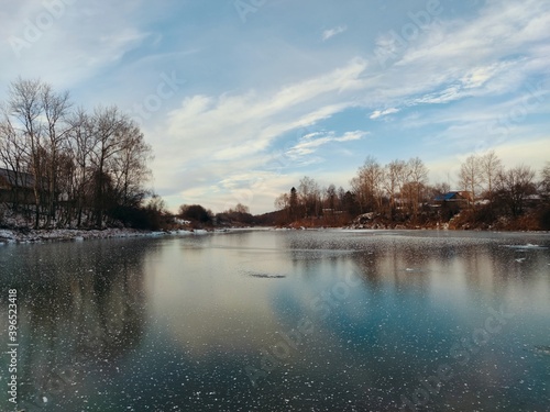 frozen snow covered lake surface against a blue sky with beautiful clouds