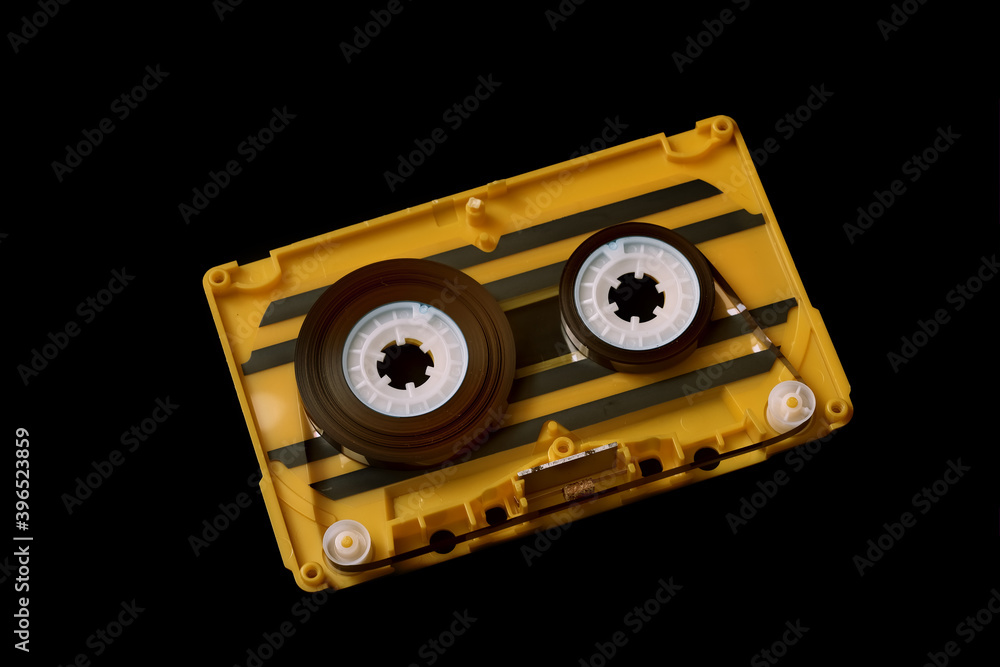 Fototapeta premium old yellow audio cassette tape on black background