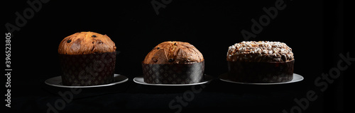 Photos three types of Italian panettone: high, low and with almonds on a black backgrou
