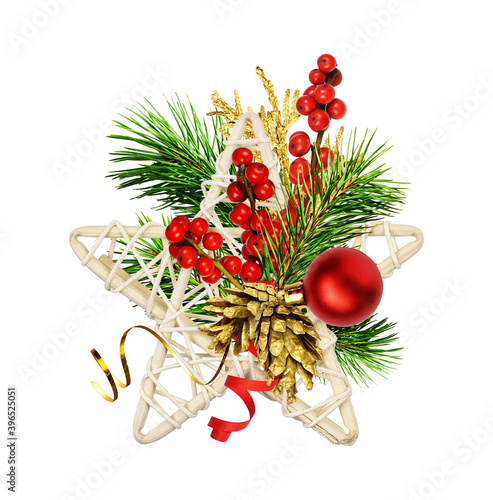 Dry rattan star with Christmas decorations, red berries and green pine twigs