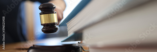 Wooden gavel for judge on table next to folder with documents. Justice and law enforcement concept