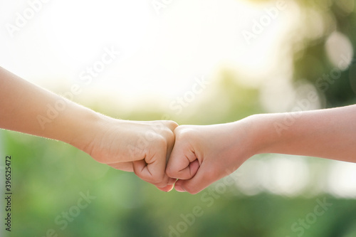 two children fists hitting each other. Two hands hitting each other with their fists. © SmitMax
