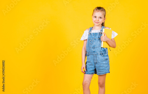 I know the answer. kid like reading. notebook for making notes. childrens literature. back to school. happy childhood. cute child on yellow background. education. beautiful teen girl with books