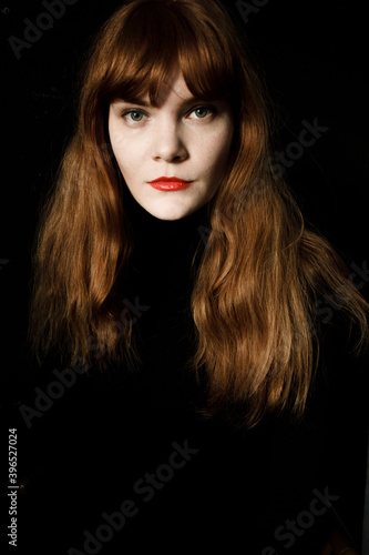 Fototapeta Naklejka Na Ścianę i Meble -  Portrait of ginger woman with red lips in black dress 