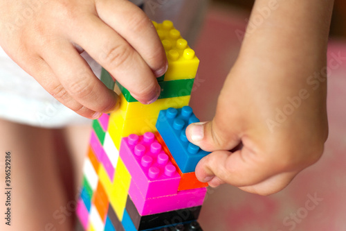 Small hands of the child collects the bright plastic colored Designer. Educational toys and Early learning