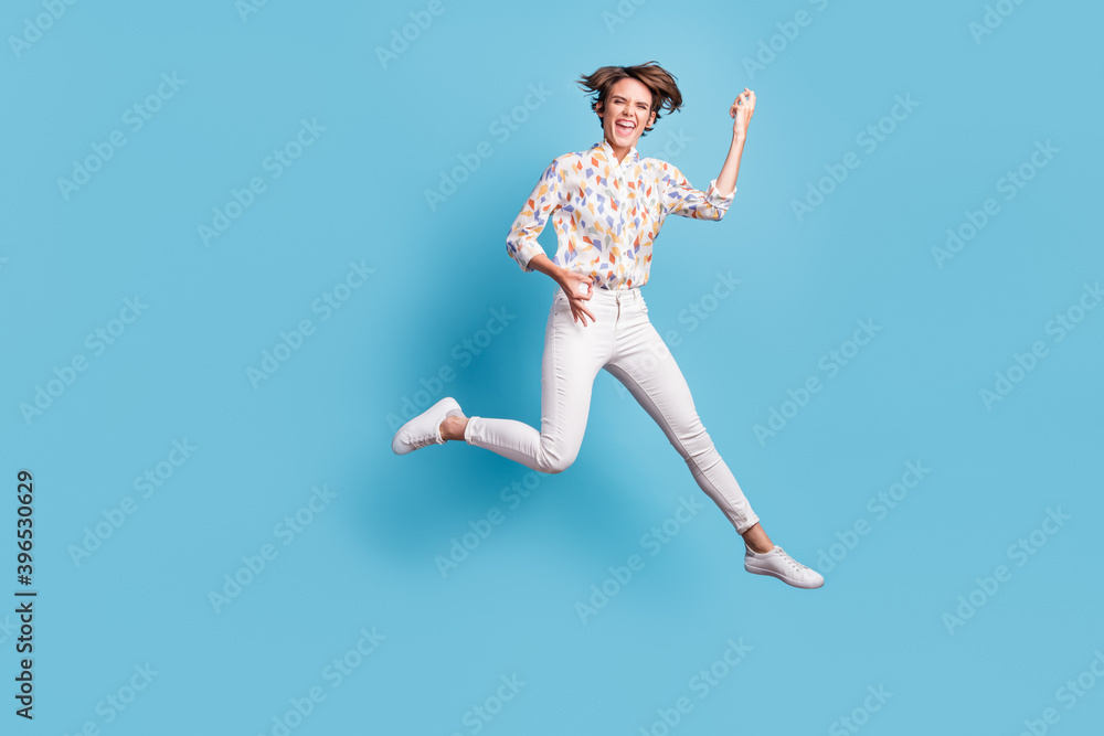 Full body photo of young girl happy smile crazy excited jump show like play guitar isolated over blue color background