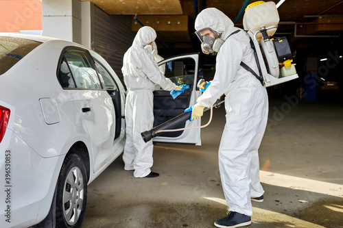 portrait of cleaners disinfecting the automobile after being in coronavirus quarantine zone, covid-19