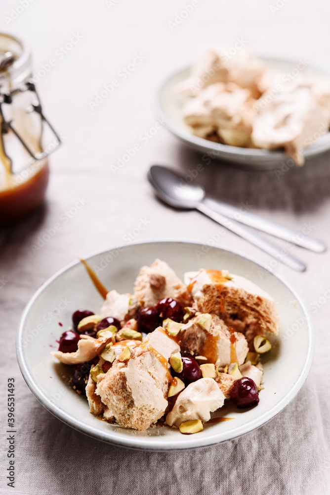 Not traditional Eton mess. Meringue, pistachio, cherry and caramel sauce dessert. Selective focus Not traditional Eton mess. Meringue, pistachio, cherry and caramel sauce dessert. Selective focus