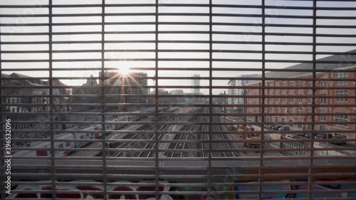 Train passes by at sunset while looking through a steel industrial grid at the North-South connection in Marolles, Brussels photo