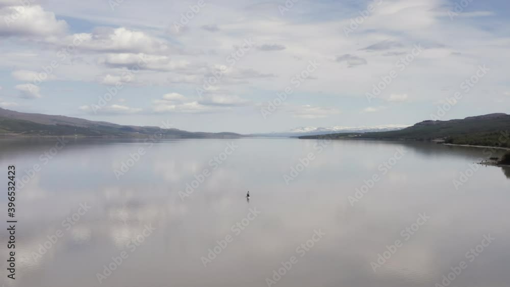Aerial at Lagarfljot lake in Iceland with lone man on standup paddle board Aerial at Lagarfljot lake in Iceland with lone man on standup paddle board
