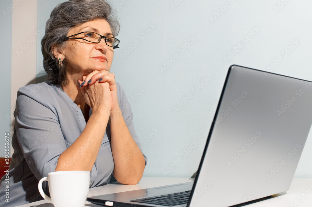 Portrait senior woman using laptop. Elderly woman pensively looking to the side. Video call concept, new normal, self-isolation Portrait senior woman using laptop. Elderly woman pensively looking to the side. Video call concept, new normal, self-isolation