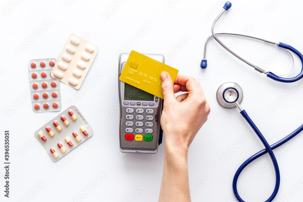 Credit card and payment terminal on doctors table. Healthcare insurance concept Credit card and payment terminal on doctors table. Healthcare insurance concept