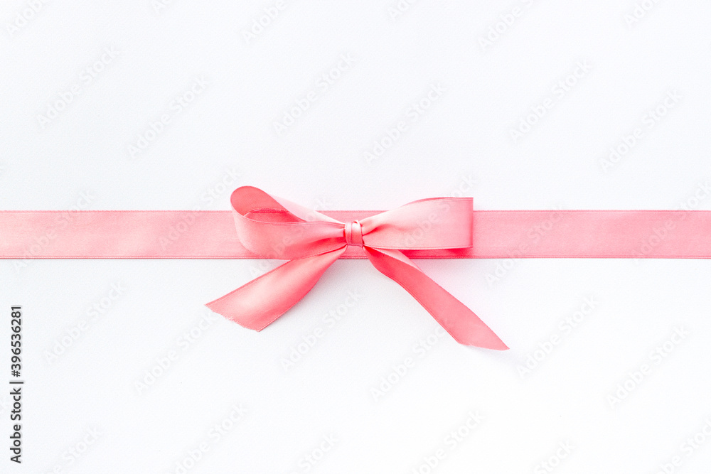 Pink ribbon with bow isolated on white. Top view, copy space Pink ribbon with bow isolated on white. Top view, copy space