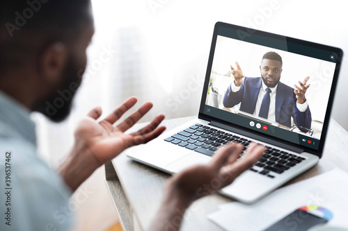 Black man fighting with his boss online, using laptop