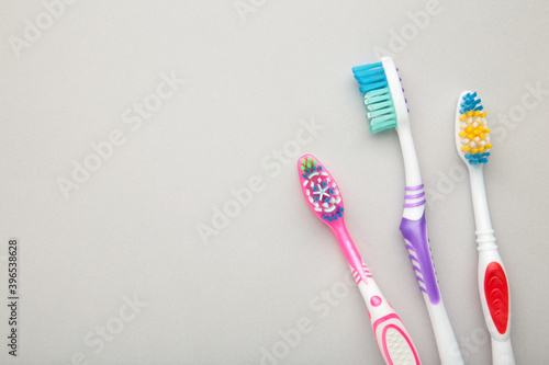 Toothbrushes on grey background with copy space.